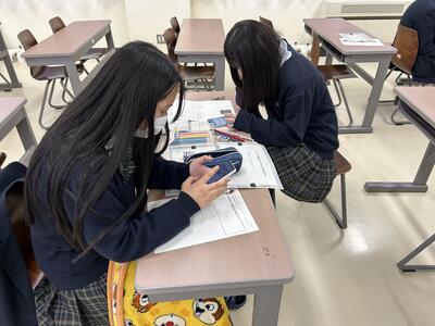 スマートフォンで名刺のデータを作る生徒